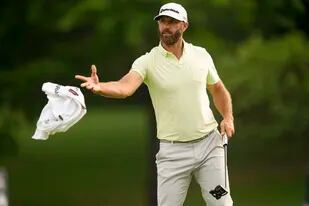 Dustin Johnson lanza la toalla a su caddie en la segunda ronda del Campeonato de la PGA, el viernes 20 de mayo de 2022, en Tulsa, Oklahoma (AP Foto/Matt York)