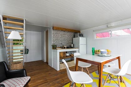 En el comedor, mesa con tapa de mármol y sillas Eiffel. El material de la construcción continuó en la mesada de la cocina, con una tapa de madera, un estante debajo y cajones de fruta como espacio de guardado.