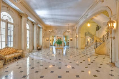 El majestuoso hall de recepción, en cuyo centro se encuentra una imponente escalera-altar de mármol blanco que conduce a las dependencias privadas del embajador, es el ambiente más espacioso de la casa. A los costados “vigilan” dos farolas venecianas talladas en madera y doradas a la hoja.