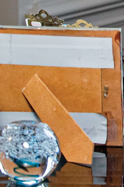 Arriba del escritorio hay un portarretratos de madera arreglado de forma casera con cinta, y dos con marco de cobre que aún tienen el precio pegado: 36,80 euros.