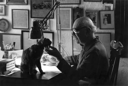 “Manucho” junto a su gato Balzac en su escritorio