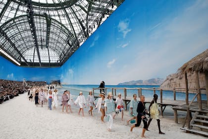 Chanel, al mando de Karl Lagerfeld, volvió a transformar el Grand Palais hoy en una playa, en la que las modelos desfilaron chapoteando en el agua con zapatos en mano.