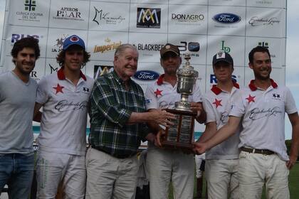 Juan Carlos Harriott le entrega la copa a Marcos Heguy, en el torneo en Coronel Suárez en 2019
