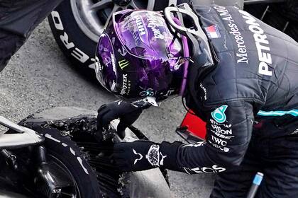 Lewis Hamilton revisa los restos del neumático delantero izquierdo del Mercedes N°44; el piloto británico firmó la victoria en Silverstone, después de desandar la última vuelta con la goma destrozada