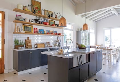 Si los muebles de color oscuro se inspiran en las cocinas inglesas, el piso de mosaico (Blangino) vino por la película Ratatouille. Lámparas colgantes (Díaz Iluminación).