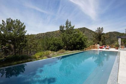 La piscina, además, está ubicada frente a un porche con chimenea y grandes sofás
