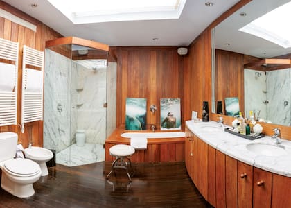 Hecho en lapacho, el baño es una oda a la sencillez. Sobre la bañadera, una serie de fotos de los hijos de la dueña de casa debajo del agua; las imágenes son obra del fotógrafo Daniel Balda.