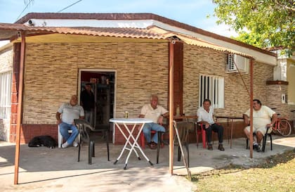Bolichito en una esquina de Romang que supo llamarse Comedor San Martín en el que varios vecinos toman "el vermucito" antes del almuerzo.