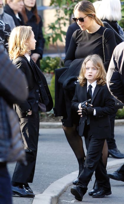 Los hermanos Hudson y Jameson Kroenig. El mayor (con las manos en los bolsillos) desfila para Chanel desde los 2 años, es ahijado de Lagerfeld y sería uno de sus herederos. Su padre es el modelo Brad Kroenig, que era considerado familia para el modisto. En la foto se los ve junto a su madre, Nicole.