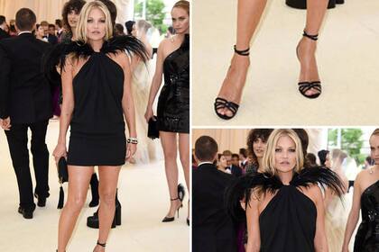 Kate Moss bellísima con un vestido negro con plumas en la parte superior que le quedaba brutal