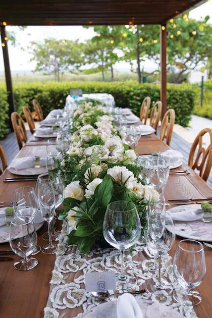 La mesa con vista al mar estaba decorada con caminos de encaje, ramos de peonías, rosas blancas y ranúnculos.