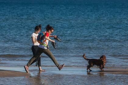 01/01/1970 Dos chicas pasean con un perro por la orilla de la playa SOCIEDAD ROBER SOLSONA / EUROPA PRESS