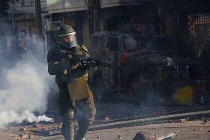 04-11-2019 Un agente de Carabineros con una escopeta antidisturbios en medio de gases lacrimógenos durante una protesta en Concepción en noviembre de 2019 POLITICA SUDAMÉRICA CHILE INTERNACIONAL AGENCIAUNO / AGENCIAUNO