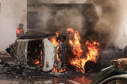 La gente intenta extinguir el fuego de los automóviles tras un ataque con cohetes desde Gaza. Militantes palestinos en Gaza dispararon inesperadamente docenas de cohetes contra objetivos israelíes la madrugada del sábado, dijo el ejército israelí