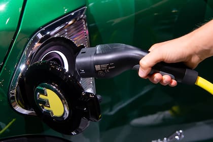 07 September 2021, Bavaria, Munich: A woman holds a charging plug for a Mini at the Mini/BMW booth during the International Motor Show (IAA Mobility), scheduled to take place from 07 to 12 September 2021. Photo: Sven Hoppe/dpa