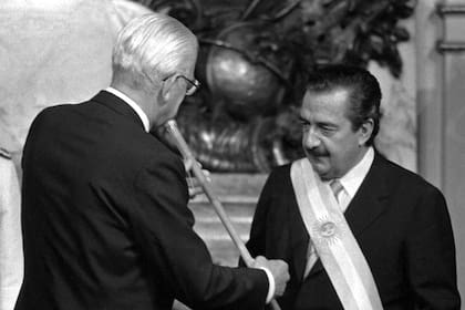 10 de diciembre de 1983. Reynaldo Bignone le otorga la banda y el bastón presidencial a Raúl Alfonsín para que se convierta en el nuevo Presidente de los argentinos