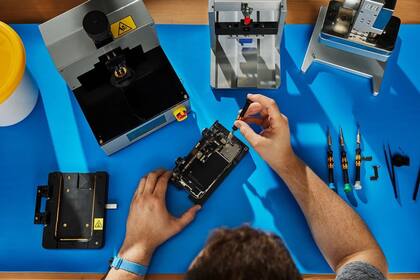 11/04/2024 Técnico sobre una mesa con piezas y herramientas reparando un iPhone POLITICA INVESTIGACIÓN Y TECNOLOGÍA APPLE