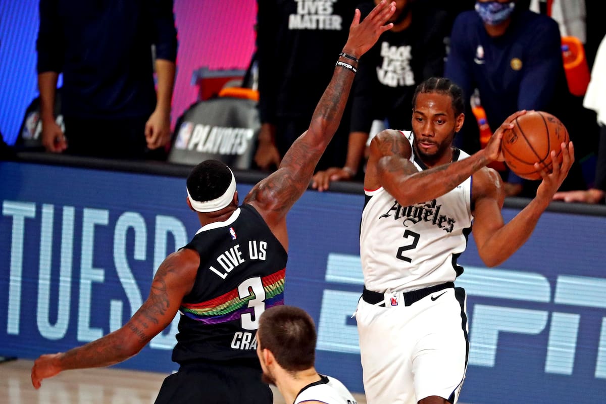 13 de septiembre de 2020; Lake Buena Vista, Florida, Estados Unidos; El alero de los LA Clippers Kawhi Leonard (2) pasa el balón contra el alero de los Denver Nuggets Torrey Craig (3) en el sexto juego de la segunda ronda de los Playoffs de la NBA 2020