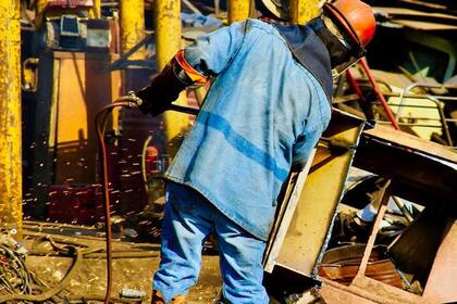 17/02/2022 Un trabajador en un desguace de coches en Prome del Norte, Ciudad Apodaca, México. ECONOMIA SALUD ONU