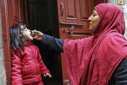 19/02/2020 Una trabajadora sanitaria vacuna a una niña de 4 años contra la polio en la puerta de su casa en el área de Lahore, en Pakistán. SALUD UNICEF/ASAD ZAIDI