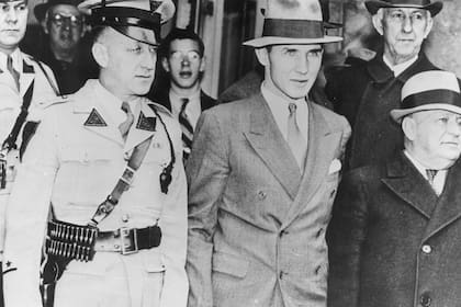 1935: Bruno Hauptmann, esposado a un policía estatal, mientras es trasladado a una cárcel de Nueva Jersey, donde fue ejecutado en la silla eléctrica