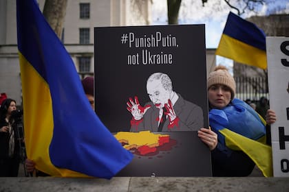 24 February 2022, United Kingdom, London: A protester holds a placard during a protest by Ukrainians against the Russian invasion of Ukraine outside Downing Street, central London. Photo: Yui Mok/PA Wire/dpa
