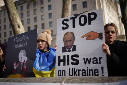 24 February 2022, United Kingdom, London: Protesters hold placards during a protest by Ukrainians against the Russian invasion of Ukraine outside Downing Street, central London. Photo: Yui Mok/PA Wire/dpa