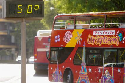 25/07/2022 Un autobús turístico pasa sin pasajeros delante de un termómetro que marca 5Oº en otro día con altas temperaturas en la capital andaluza a 25 de julio del 2022 en Sevilla (Andalucía, España) SALUD Eduardo Briones - Europa Press