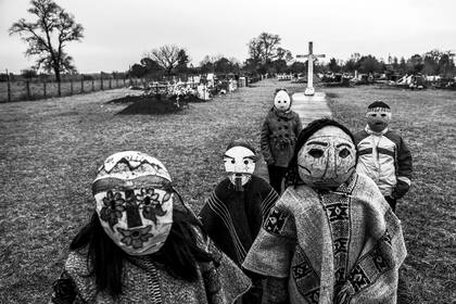 28 de julio de 2019. Maihue, Los Ríos, Chile.

Niños en el cementerio mapuche de Maihue. En las cercanías se pretende instalar una central hidroeléctrica, donde las comunidades de la zona se oponen al proyecto. Las máscaras se utilizan en los "guillatunes", ceremonias que realizan las autoridades espirituales una vez al año.