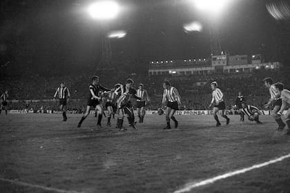 43) Enredados en el área; Estudiantes propuso un planteo defensivo en Uruguay para capitalizar la ventaja obtenida en La Plata; Echecopar, frente a la pelota y atrás llega Pagnanini