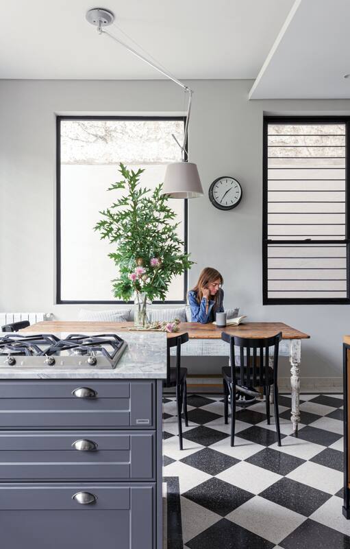 Foto de un comedor con piso de madera y mesa con estructura de hierro y tapa de Technistone.