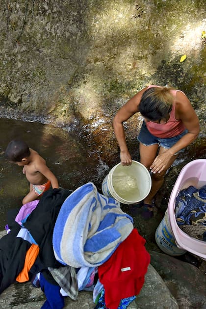 En fotos: por los apagones, en Caracas buscan agua y se bañan en un parque nacional