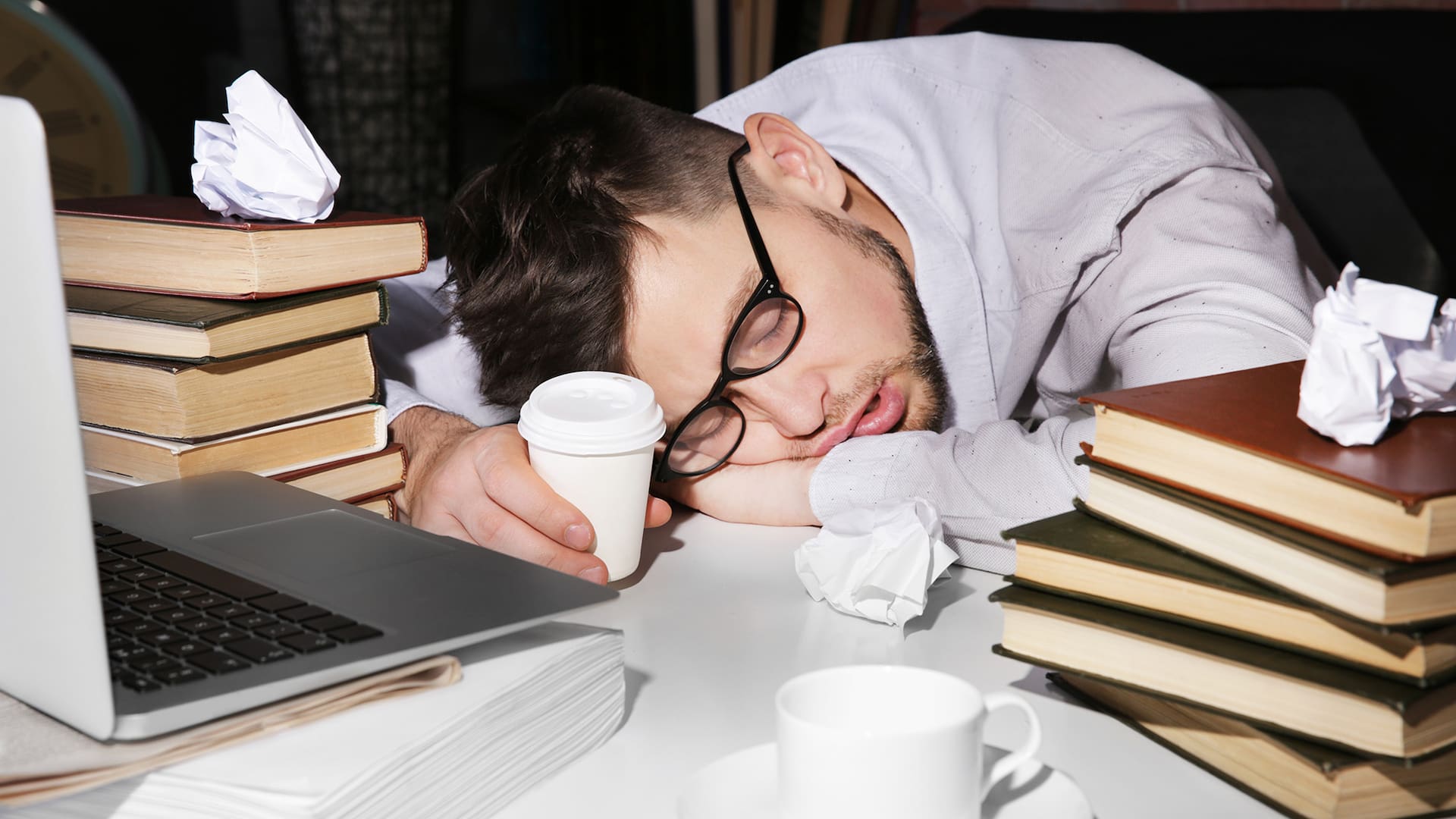 Young man fell asleep during reading at workplace