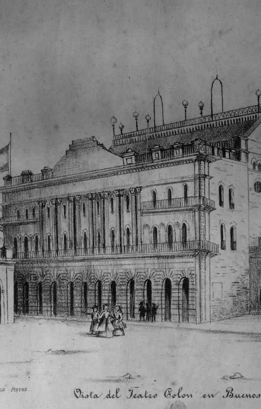Vista del primer Teatro Colón que ostenta la bandera argentina. Estaba ubicado al borde de la Plaza de Mayo en la calle Rivadavia, donde hoy se encuentra el Banco Nación. Allí comenzó a tejerse esta historia de amor.