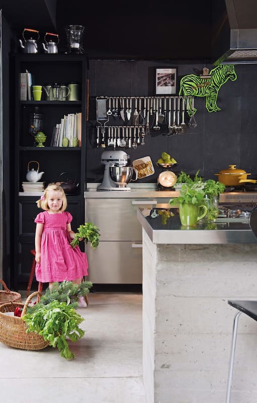 Foto de una cocina con cajas de madera, barral y panera, cartel de menú y especiero.
