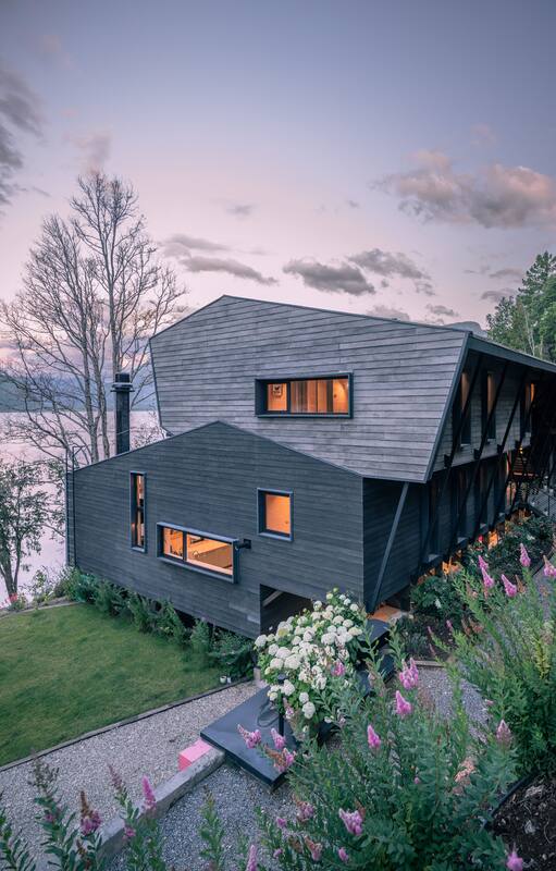 Hecha en madera, una casa de 11 metros de altura encontró su lugar entre la montaña y el lago