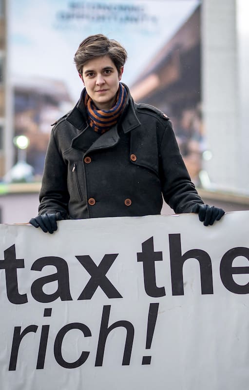 a austriaca Marlene Engelhorn, que heredó de su familia la propiedad del gigante químico alemán BASF, posa con un cartel que dice "¡Graven a los ricos!". en la entrada del centro de congresos en la inauguración de la reunión anual del Foro Económico Mundial (FEM) en Davos, el 15 de enero de 2024.