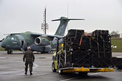 A Brazilian military man checks the loading of equipment to a Brazilian Air Force plane for a humanitarian aid mission to Venezuela following deadly earthquakes, at Guarulhos air base in Guarulhos, Sao Paulo state, Brazil, on July 26 2026. Desperate Venezuelans raced to find and rescue loved ones trapped alive beneath the rubble of collapsed buildings after two major earthquakes, measured at magnitudes 7.2 and 7.5, hit northern Venezuela killing -up to now- 589 people and leaving more than 1,500 injured. (Photo by NELSON ALMEIDA / AFP)