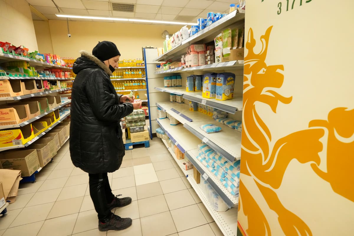 A buyer stands in front of empty shelves in a food shop in Zaporizhzhia, Ukraine, Friday, Feb. 25, 2022. Russia is pressing its invasion of Ukraine to the outskirts of the capital after unleashing airstrikes on cities and military bases and sending in troops and tanks from three sides. (AP Photo/Sergei Grits)