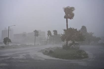 A car is seen parked as it rains heavily in Fort Myers, Florida, on October 9, 2024 as Hurricane Milton approaches. Milton regained power on October 8 to become a Category 5 storm with maximum sustained winds of 165 mph (270 kph) as it barrels towards the west-central coast of Florida and is forecast to make landfall late October 9, according to the National Hurricane Center