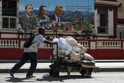 Un cubano empuja una carretilla de residuos en una calle de La Habana