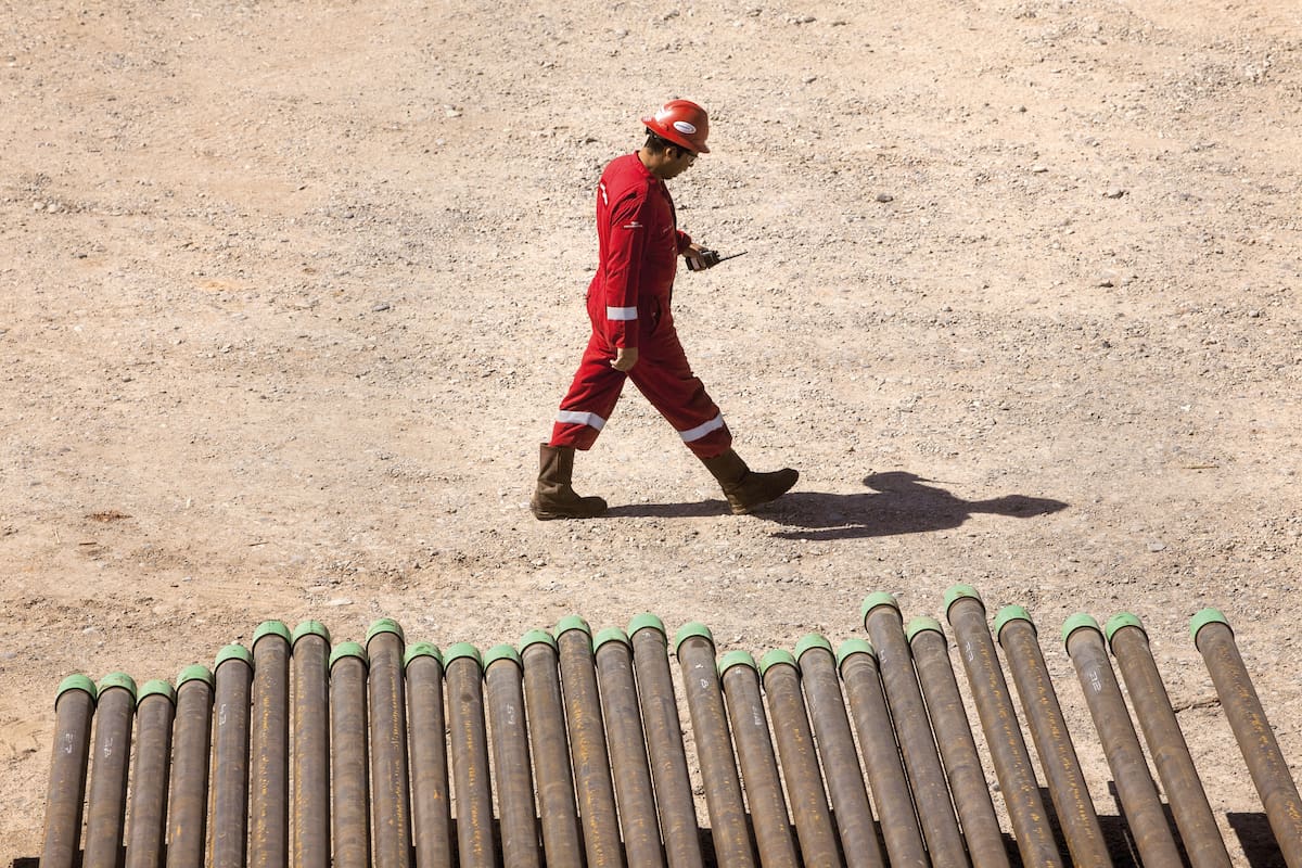 A-ELO, NEUQUEN - SEPTEMBER 15: A worker walks in front of oil tubes for pipe oil lines and gas pipe lines on Loma Campana area at Vaca Muerta on September 15, 2014 in Añelo, Argentina. Vaca Muerta is a shale geological formation originally discovered by Charles Edwin Weaver in 1931 and confirmed by YPF in 2011. Several oil companies have presented projects to extract shale oil and shale gas. (Photo by Ricardo Ceppi/Getty Images)