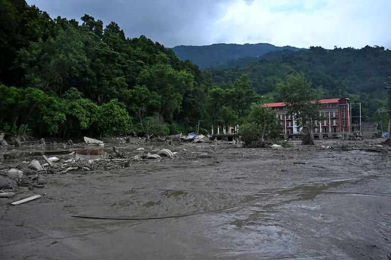 A house lies deluged in sludge after flash floods at Devghat in Nepal's Nuwakot district on August 26, 2026. Massive flooding killed eight people in Nepal on August 26, as Chinese state media reported "major casualties" from a mudslide at a Tibet trade hub on China's side of the nations' shared border. (Photo by Prabin RANABHAT / AFP)