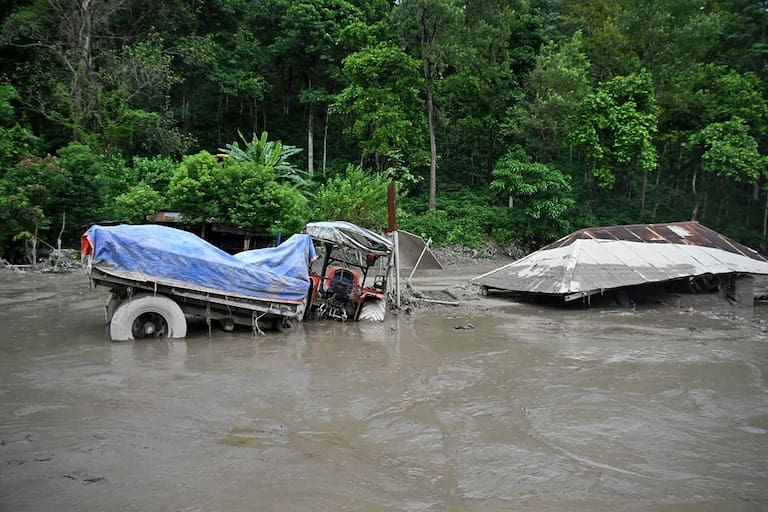 A house lies deluged in sludge after flash floods at Devghat in Nepal's Nuwakot district on August 26, 2026. Massive flooding killed eight people in Nepal on August 26, as Chinese state media reported "major casualties" from a mudslide at a Tibet trade hub on China's side of the nations' shared border. (Photo by Prabin RANABHAT / AFP)