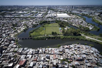A la izquierda de la península, la vía del tren que cruza el Riachuelo y es el único acceso desde la ciudad. Por la derecha, la conexión con tierra con el partido de Avellaneda. Alrededor está la villa 21-24