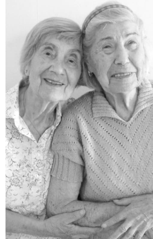 A la izquierda, las hermanas Bracha y Katka Berkovic poco antes de que desatarse la II Guerra Mundial; a la derecha, las costureras recrean la misma foto en 2013. (Foto: Gentileza de Lucy Adlington)