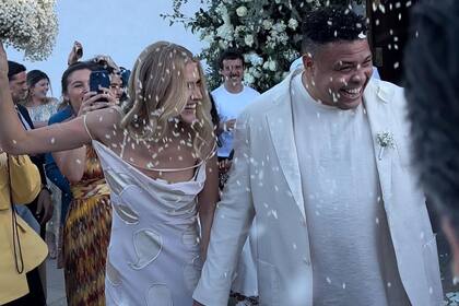 A la salida de la parroquia los invitados arrojaron arroz y pétalos de rosas blancas a la feliz pareja.