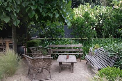 A la sombra de un gran tilo, sillones y una mesa hacen las veces de living al aire libre.