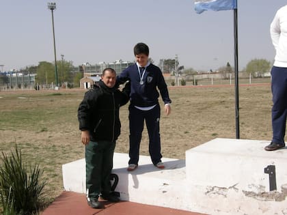 A los 14, en un podio con su papá
