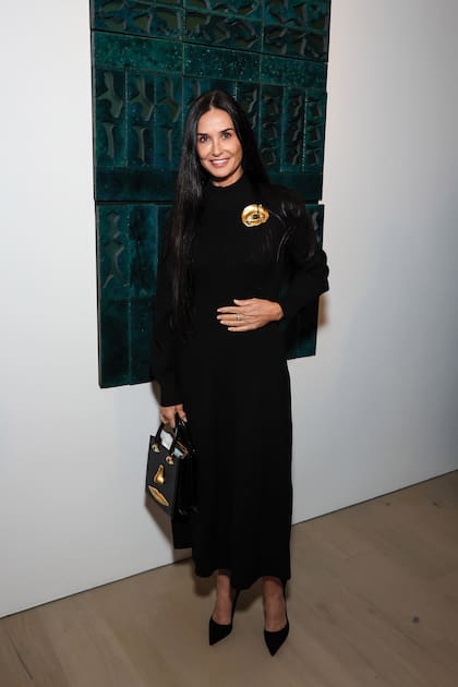 A los 60 y espléndida como siempre, Demi Moore dijo presente con un vestido largo negro que accesorizó con un broche dorado en forma de ojo by Schiaparelli y minicartera de la misma casa italiana.